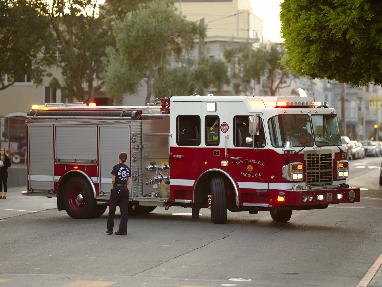 A firefighter fastening protective gear beside a red fire engine at Shaw Air Force Base